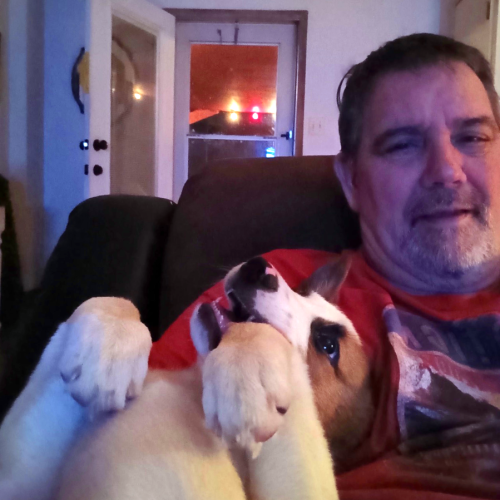 A picture of David George and his dog, Buster, sitting in a chair.