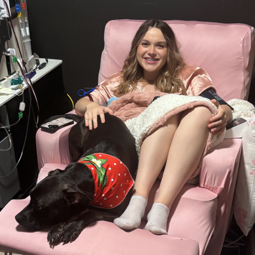 Llana Wright, a 20 year old young woman seeking a kidney donor, sitting in a chair with her dog.